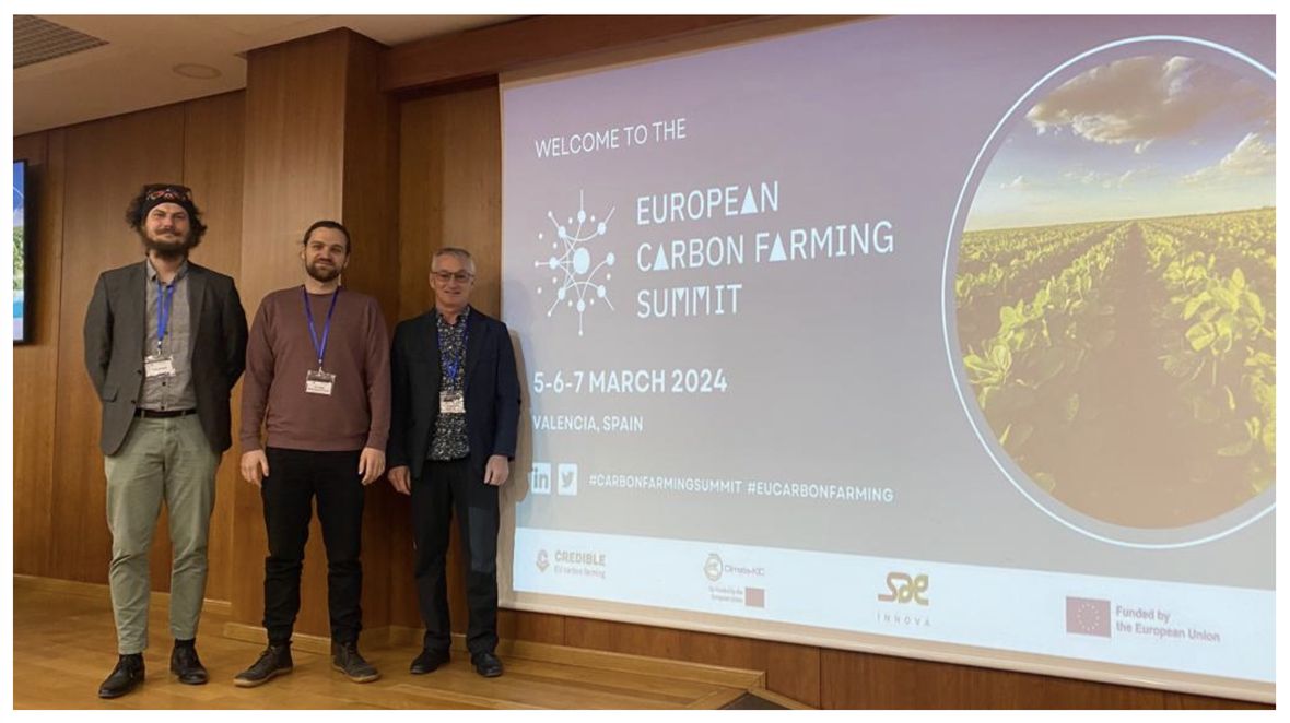Traja účastníci pred plátnom s programom prvého European Carbon Farming Summit vo Valencii